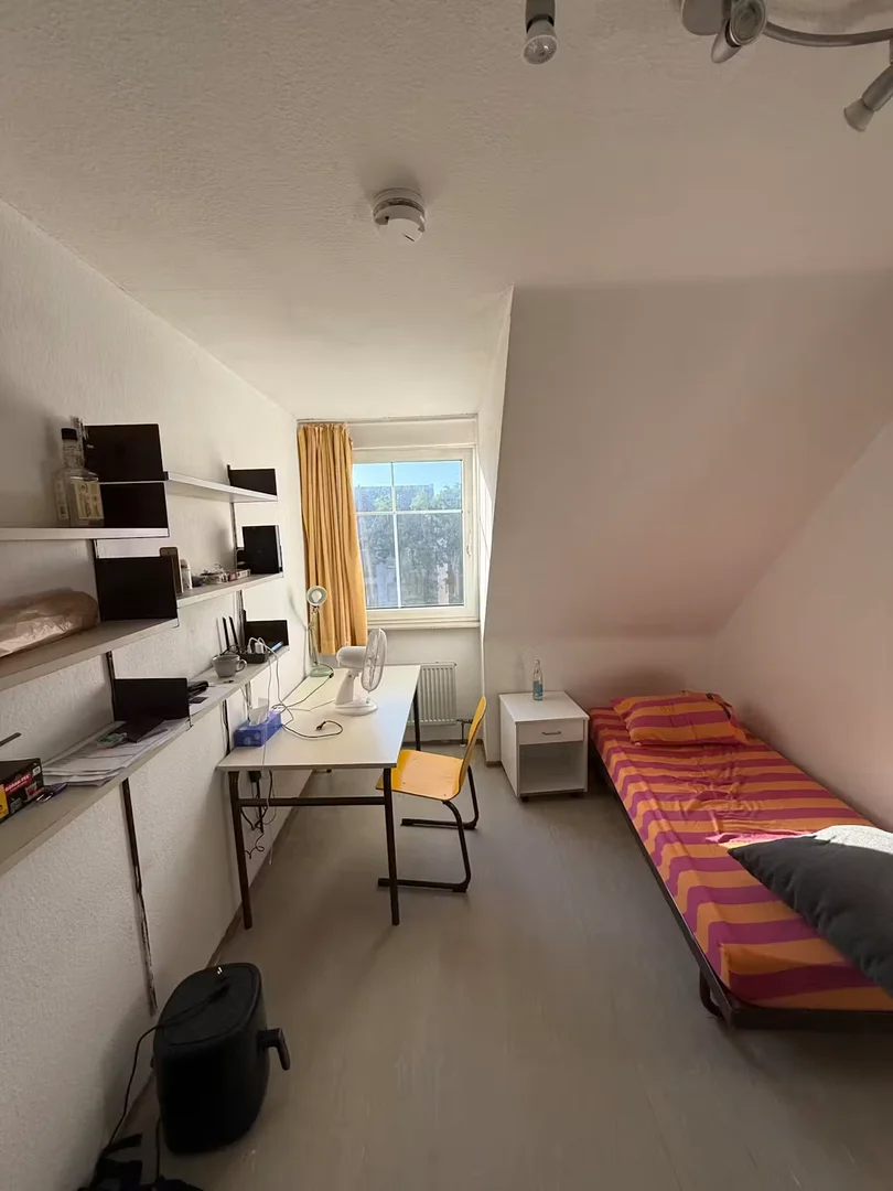 Quarto de estudante luminoso e arejado com acesso fácil à universidade em 