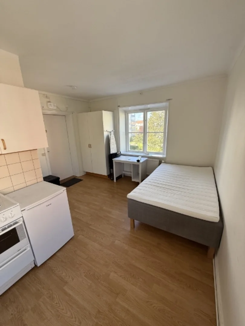 Quarto de estudante luminoso e arejado com acesso fácil à universidade em 