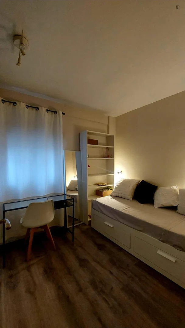 Quarto de estudante luminoso e arejado com acesso fácil à universidade em 