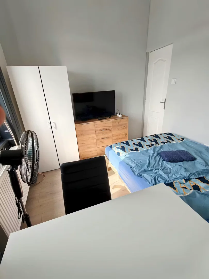 Quarto de estudante luminoso e arejado com acesso fácil à universidade em 