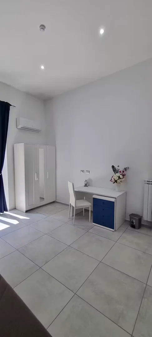 Quarto de estudante luminoso e arejado com acesso fácil à universidade em