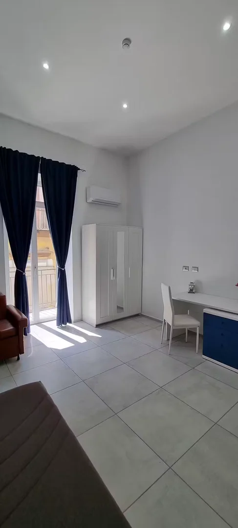 Quarto de estudante luminoso e arejado com acesso fácil à universidade em
