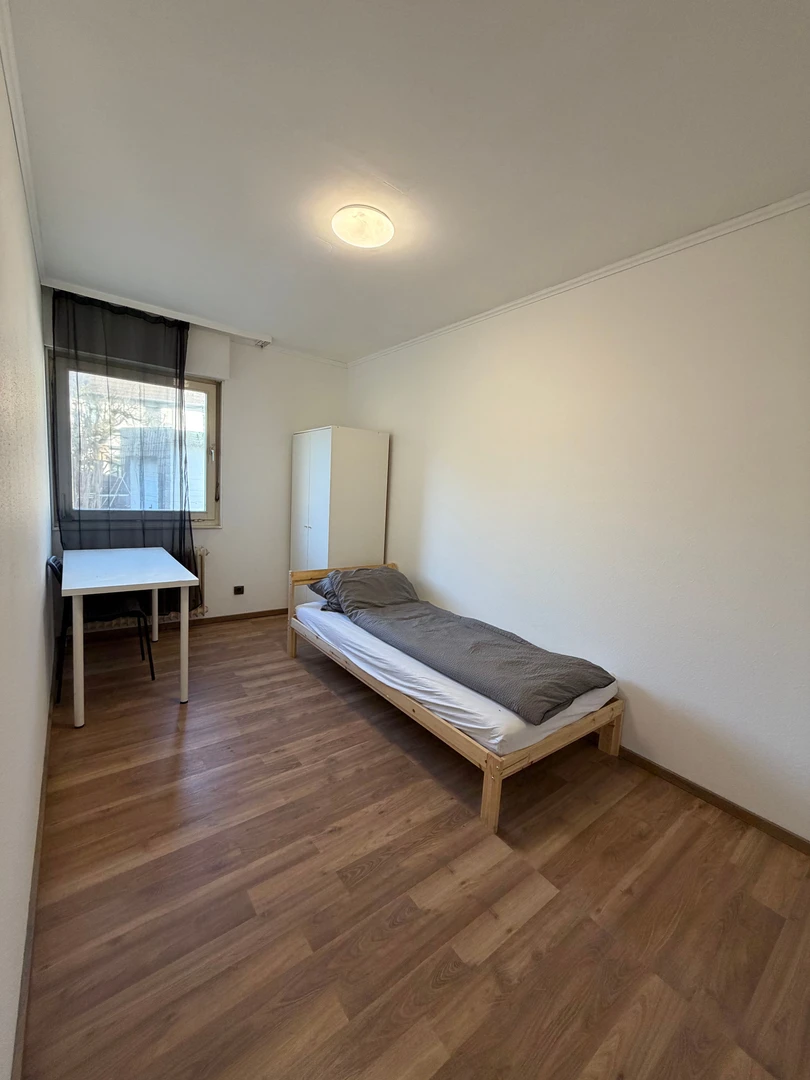 Quarto de estudante luminoso e arejado com acesso fácil à universidade em 